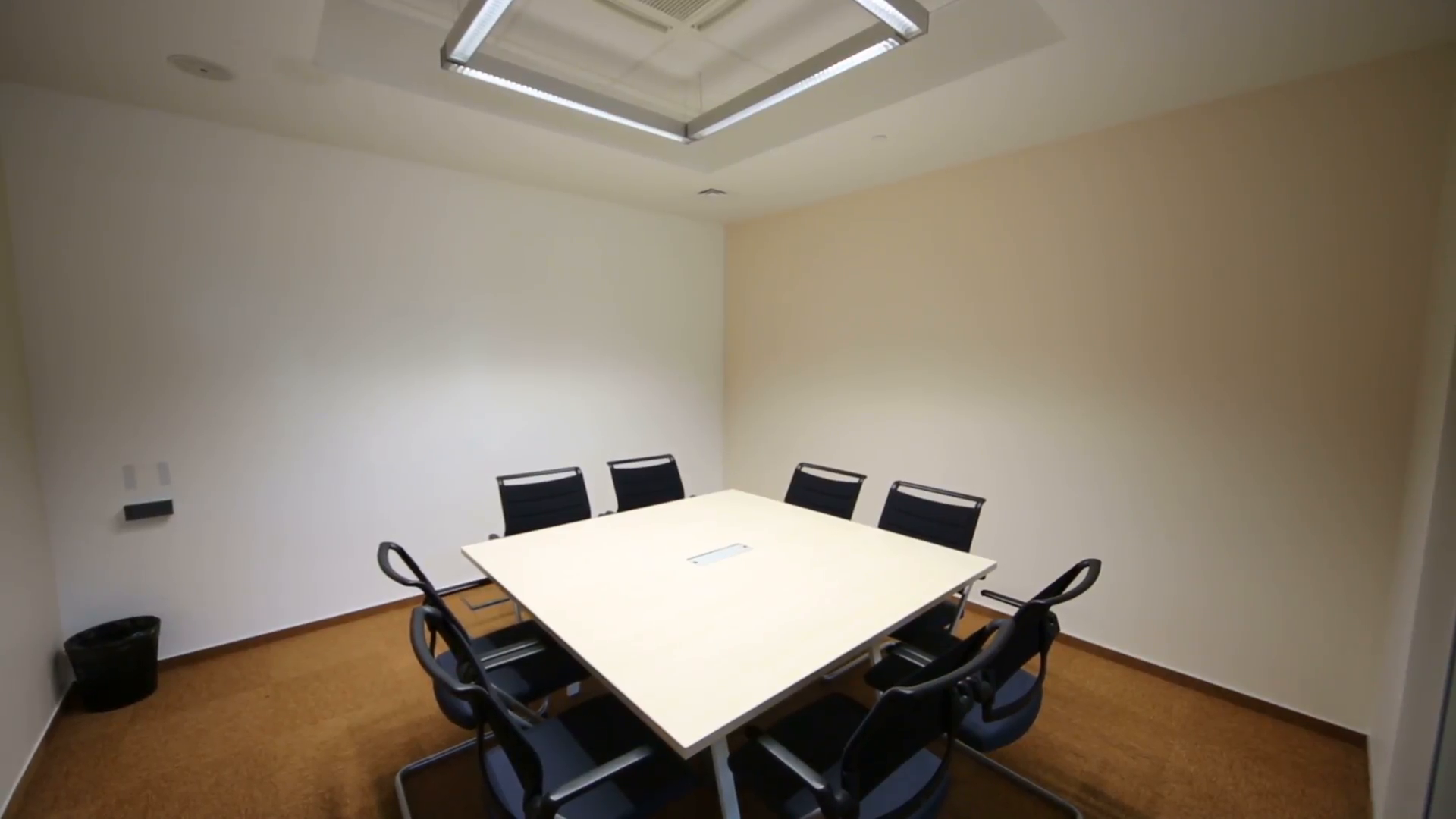 empty-small-meeting-room-with-table-and-chairs-in-modern-building_v1hvu0zge__f0000